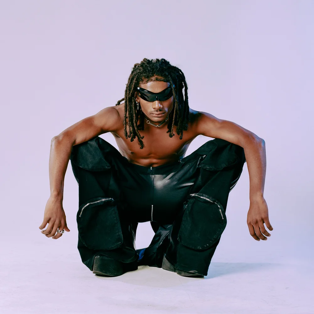 model-black-leather-squatting-lavender-backdrop-fashion-editorial.jpg