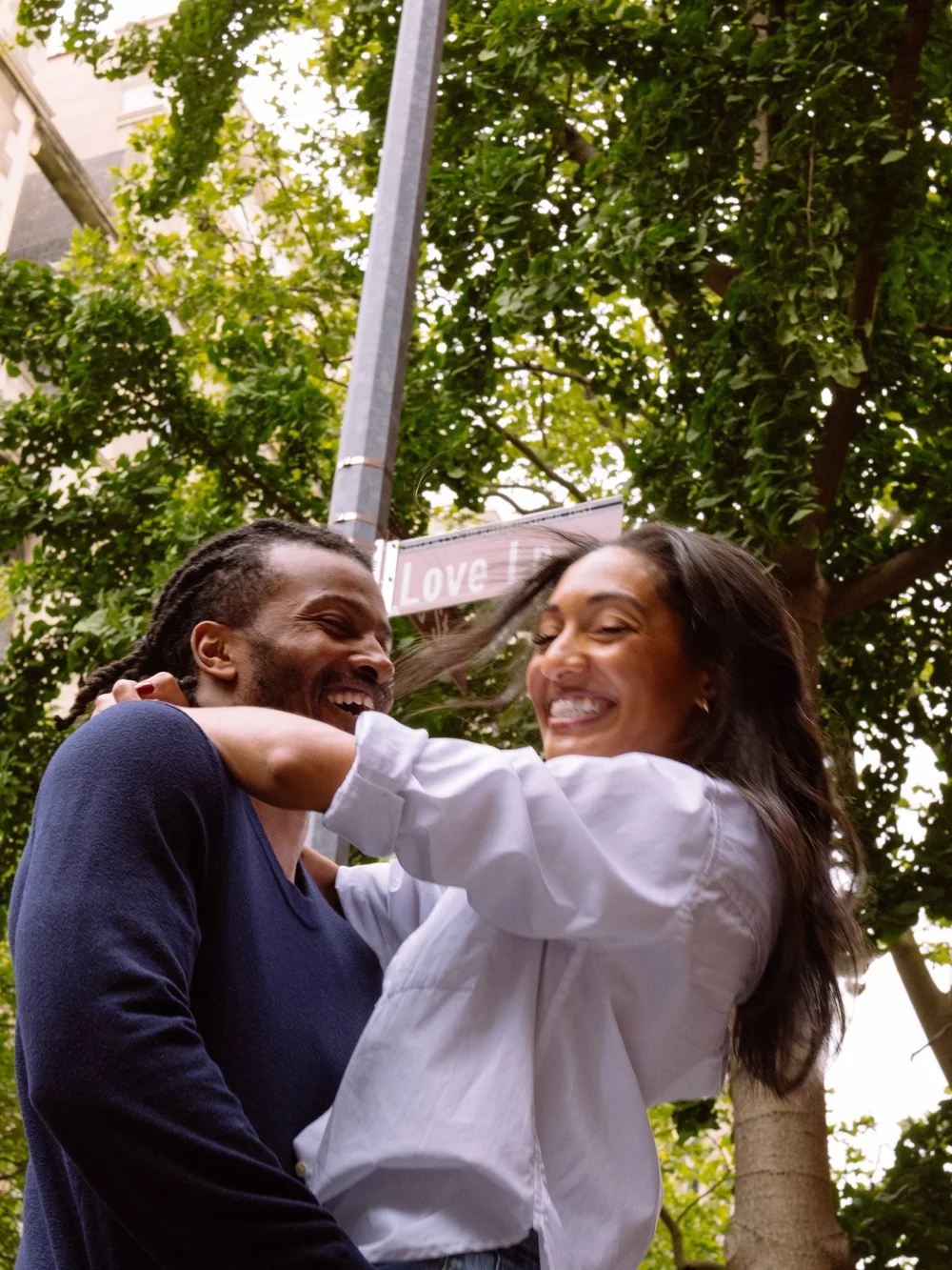 engagement-couple-laughing-under-street-sign.jpg