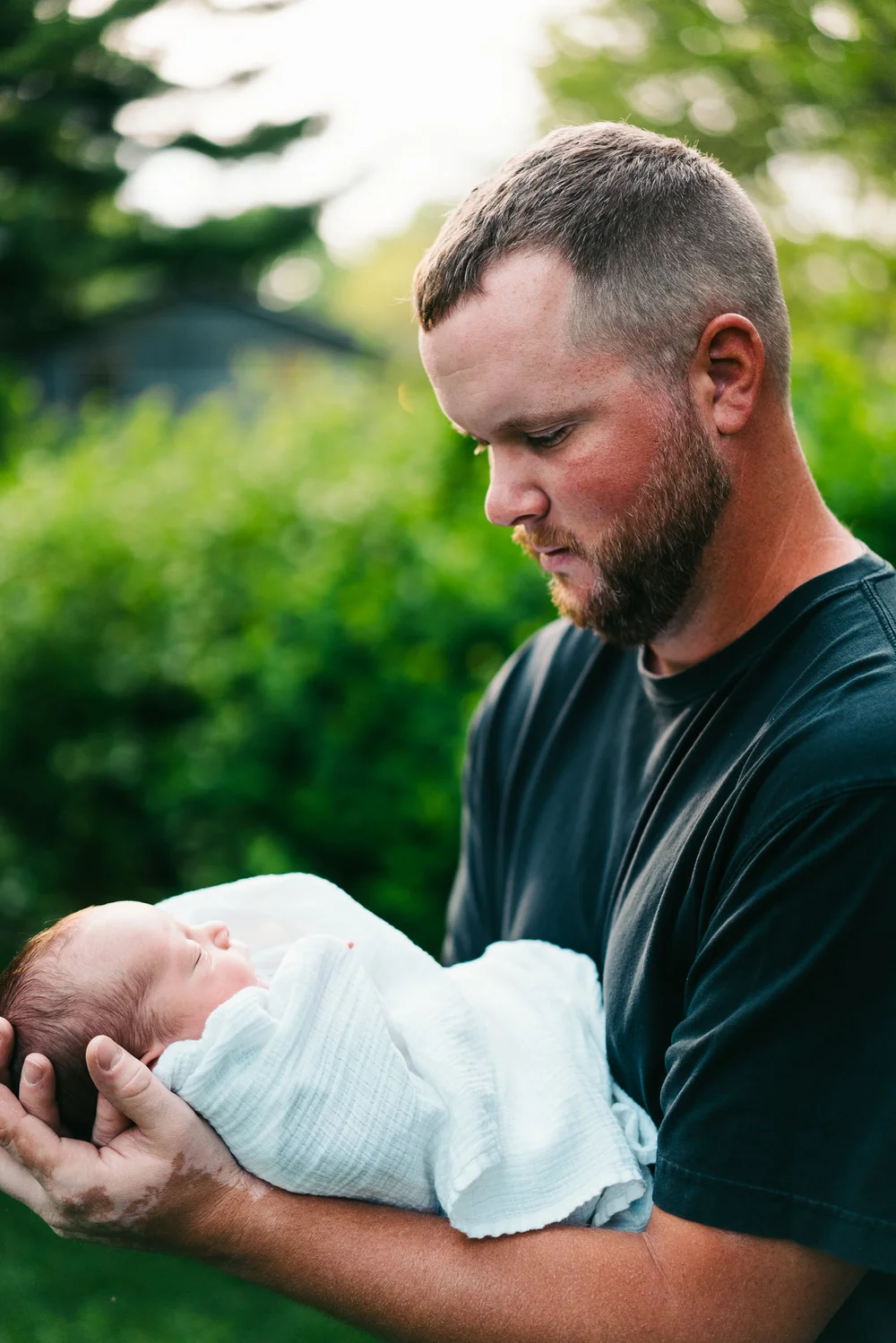 father-looking-at-newborn-outdoors.jpg