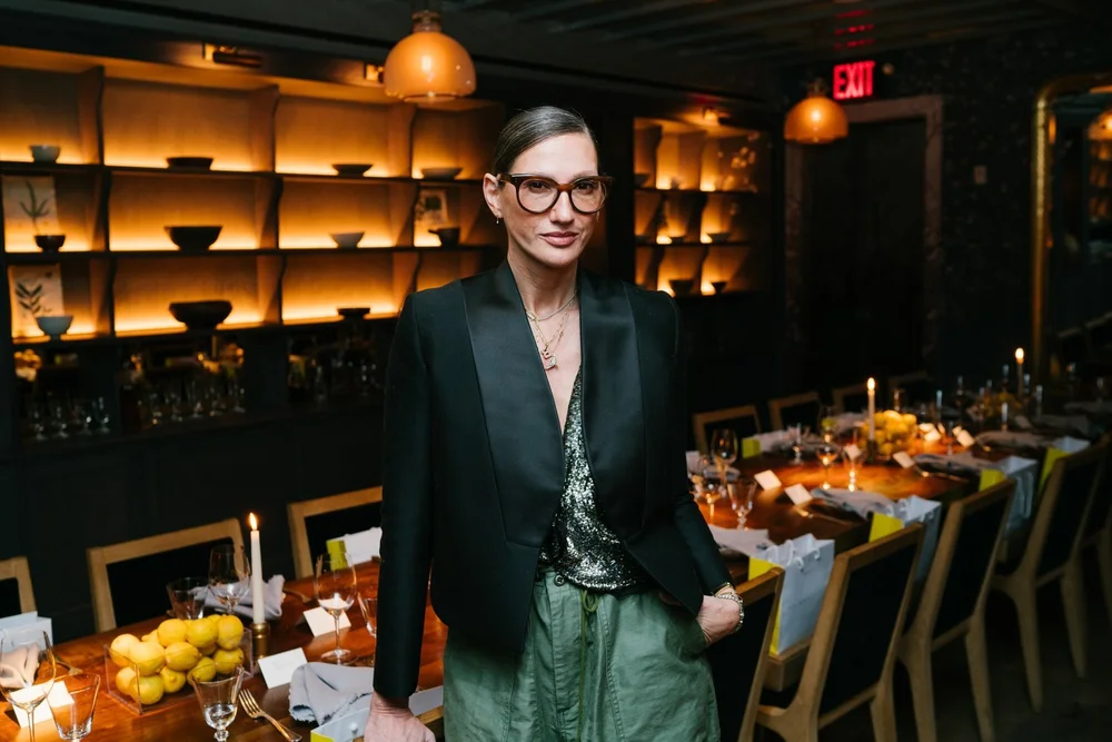 Guest in a black blazer standing beside the set table at the Trinny London VIP dinner