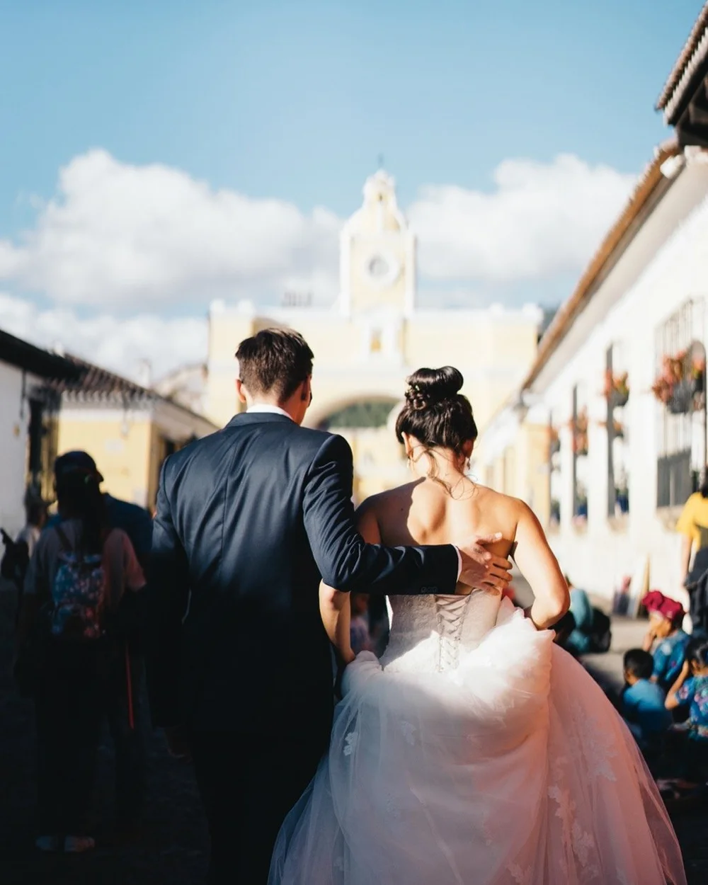 bride-groom-walking-sunny-street-wedding.jpeg