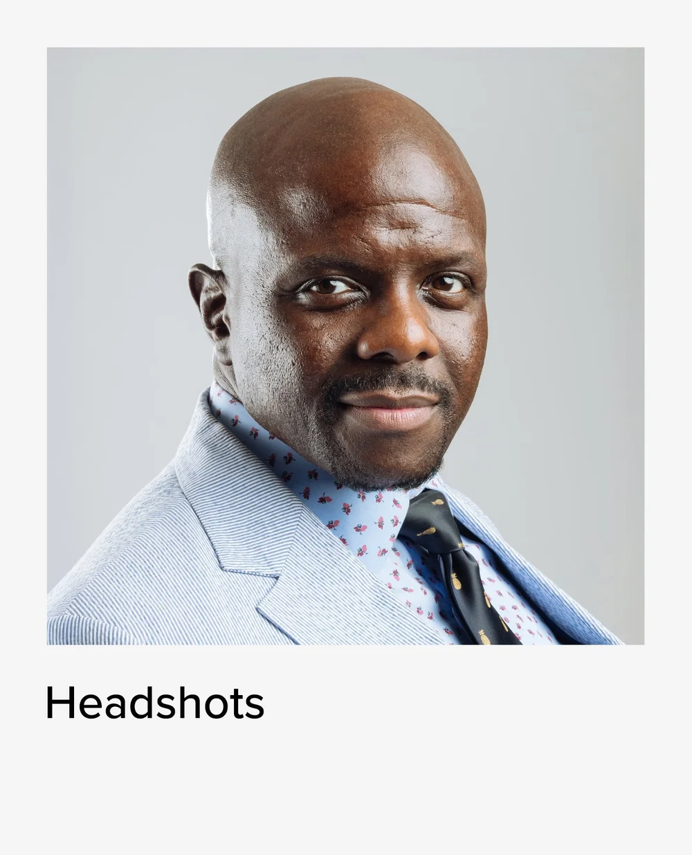 Headshot of a man in a light blue suit, professional headshot photographer in NYC