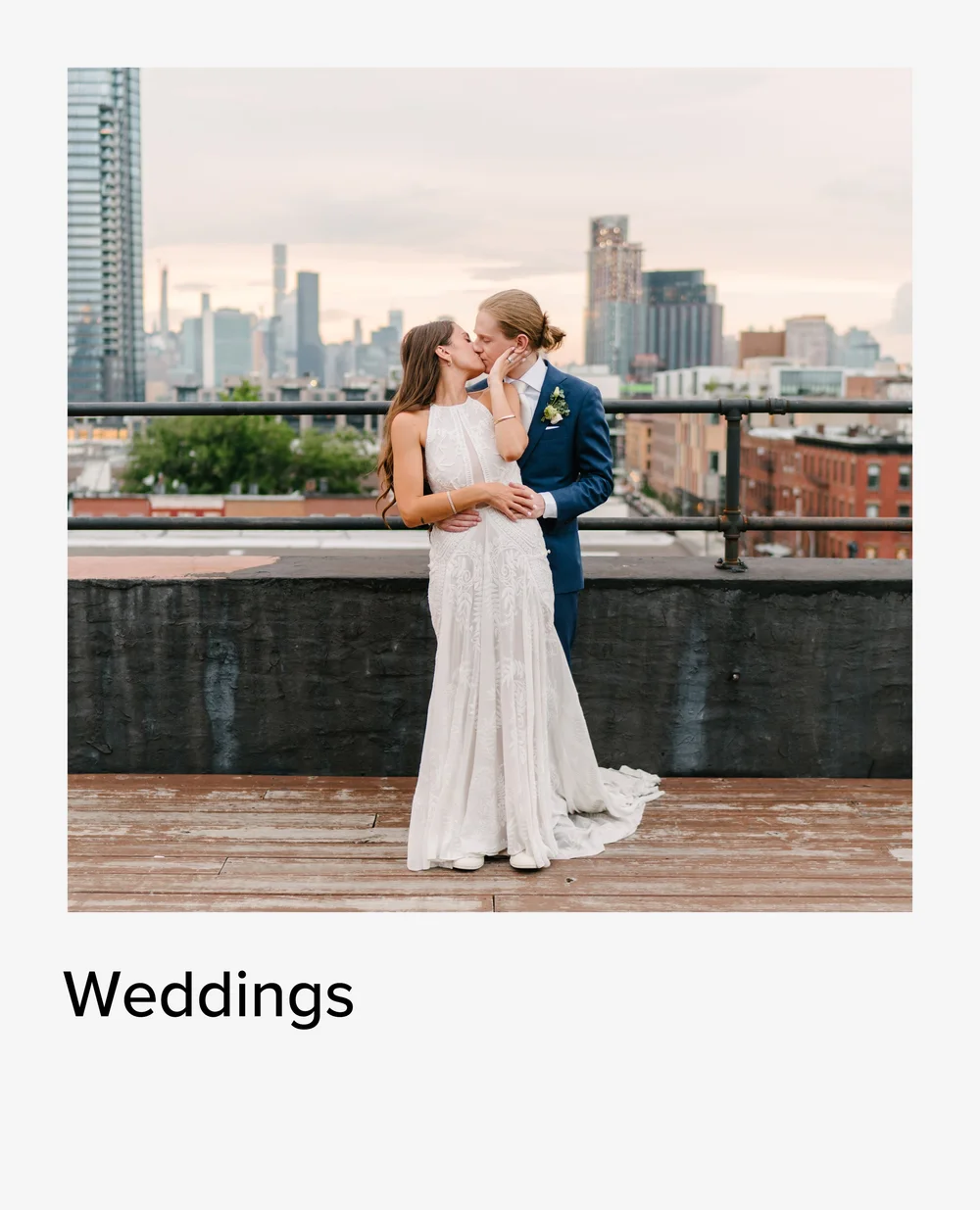 Wedding couple kissing on a rooftop with the Manhattan skyline behind them