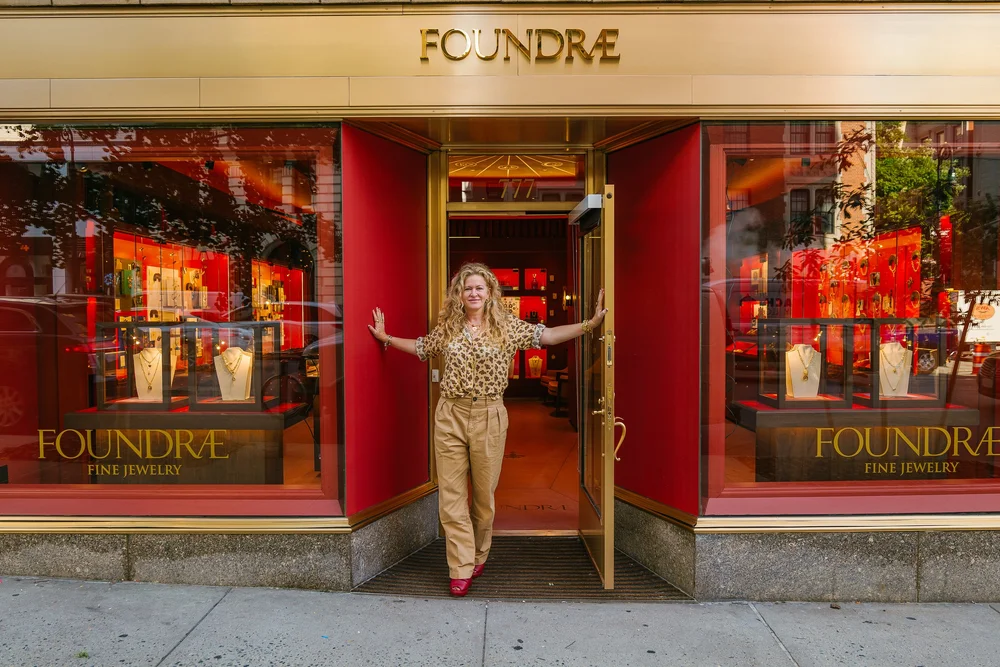 Founder portrait in the doorway of the red Foundrae storefront in Manhattan
