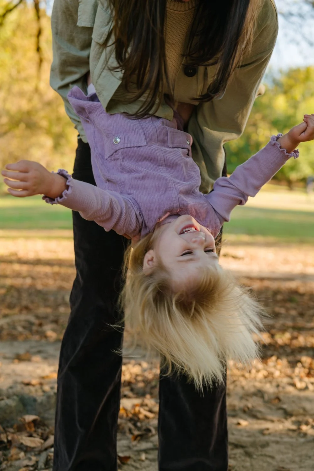 parent-holding-toddler-upside-down-park.jpg