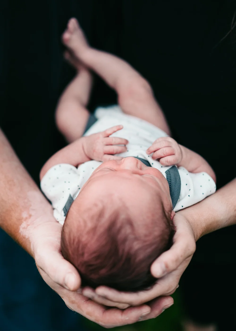 newborn-held-up-parents-hands.jpg