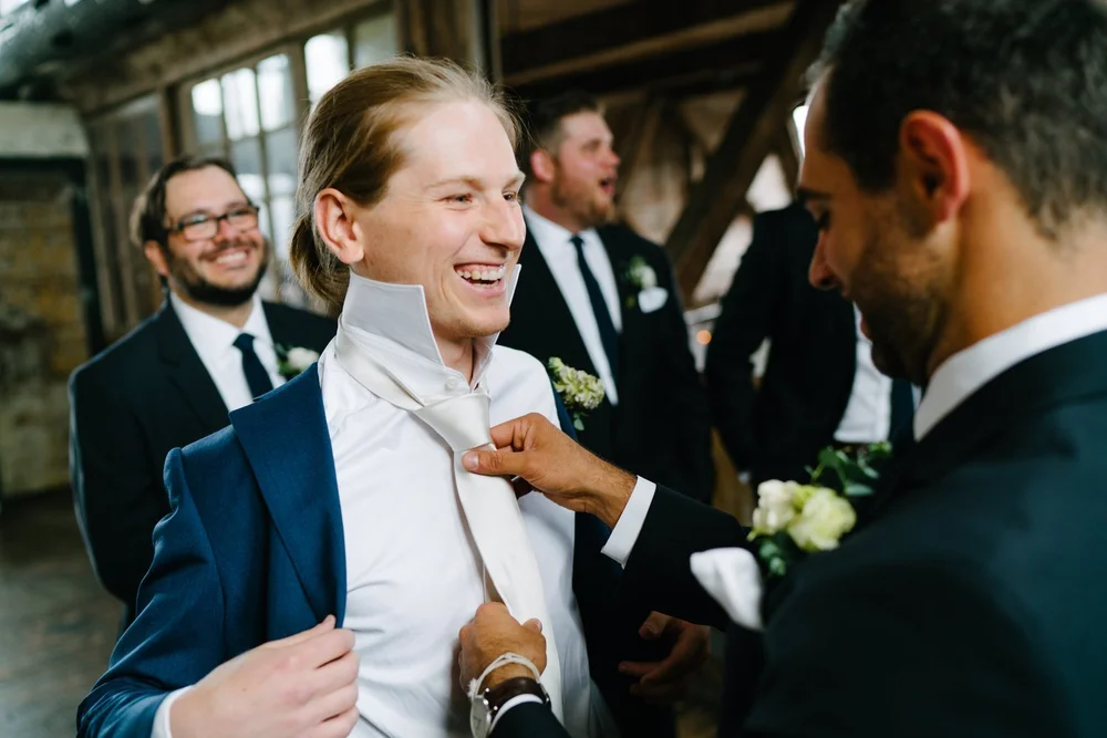 groom-groomsmen-getting-ready-tie.jpg