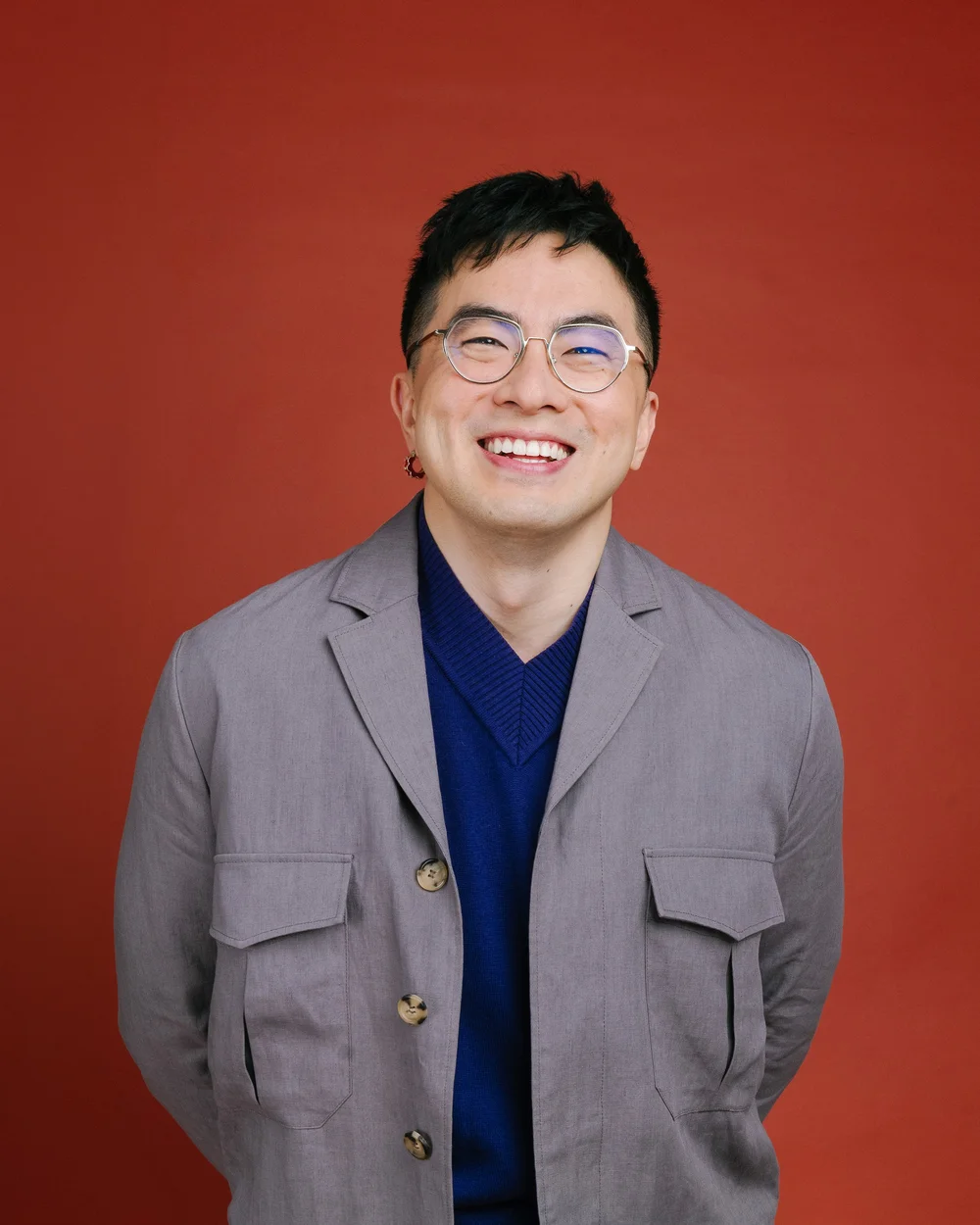 Smiling portrait of Bowen Yang in a gray blazer for NYC Pride 2026